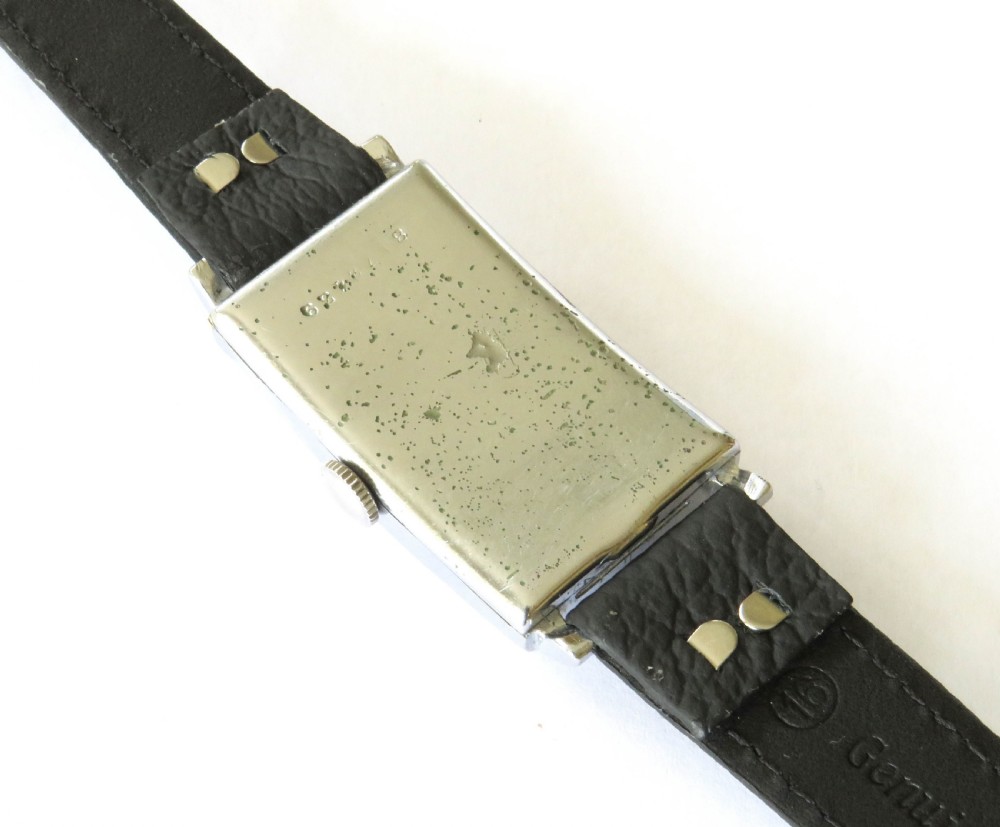 A 1938 gents Zenith wristwatch featuring a rectangular silver-tone case, a cream dial with Art Deco numerals and sub-seconds dial, fitted on a black leather strap. View IV
