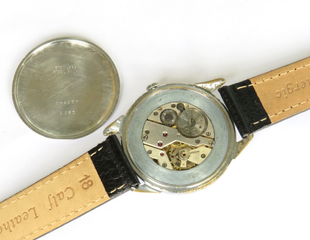 A vintage 1950s Dogma Prima gents wristwatch with a cream patinated dial, Arabic numerals, sub-seconds display, and a black leather strap. View III