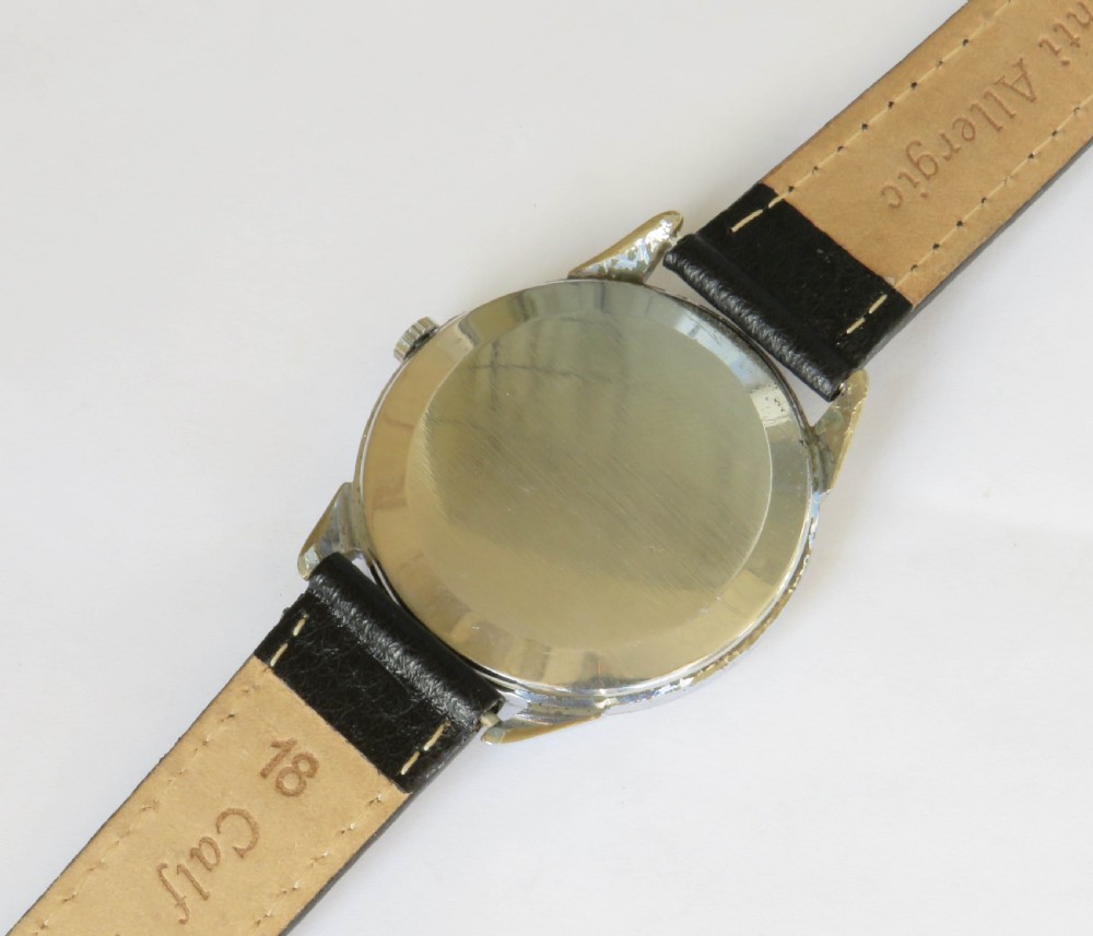 A vintage 1950s Dogma Prima gents wristwatch with a cream patinated dial, Arabic numerals, sub-seconds display, and a black leather strap. View IV