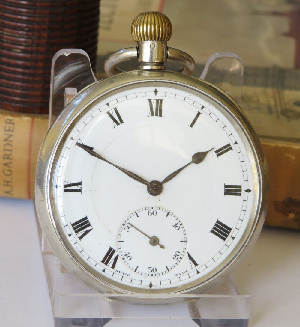 An open-face antique silver pocket watch with a white enamel dial, black Roman numerals, sub-seconds dial, and a ribbed crown. View II