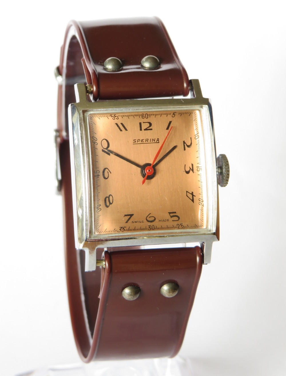 A gents 1940s Sperina wristwatch featuring a square copper-coloured dial, black Arabic numerals, a red second hand, and a brown riveted strap. View II