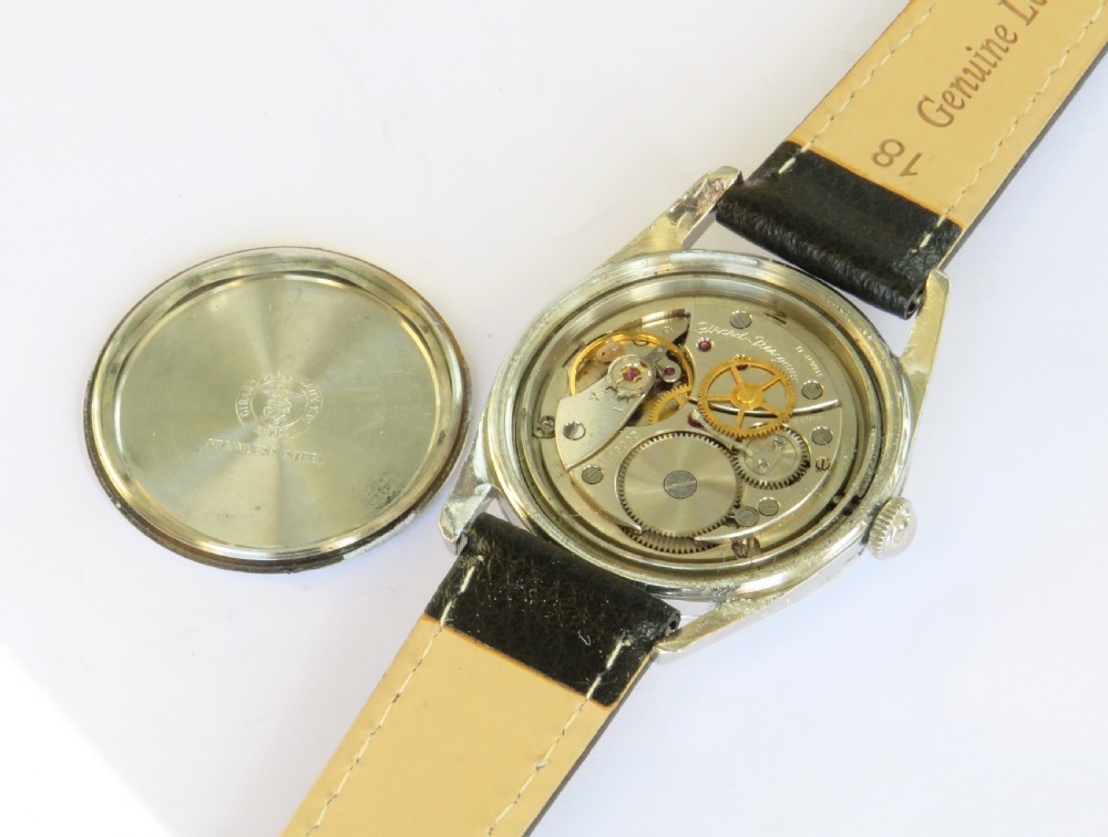 A vintage 1960s Girard-Perregaux wristwatch featuring a champagne dial, silver-tone stainless steel case, baton hour markers, and a black leather strap. View III