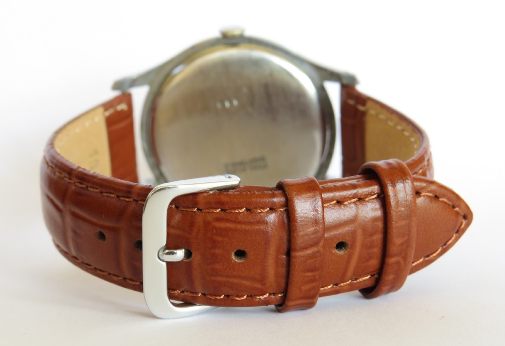 A 1940s Enicar mechanical gents wrist watch featuring a cream dial with gold-tone Arabic numerals, red second hand, and a brown leather strap. View V