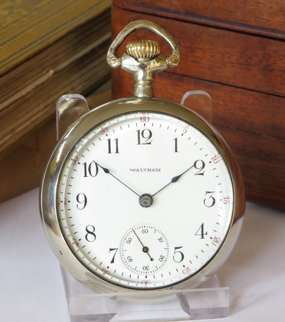 An open-face Edwardian pocket watch featuring a white enamel dial with black Arabic numerals, a subsidiary seconds dial, and a silver-toned metal case. View II