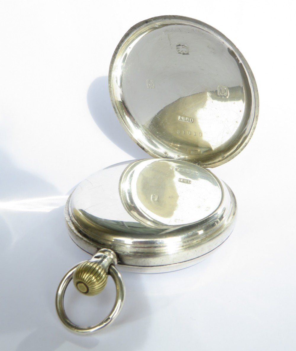 An open face silver pocket watch featuring a white enamel dial with black Arabic numerals, gold hands, and a subsidiary seconds sub-dial. View III