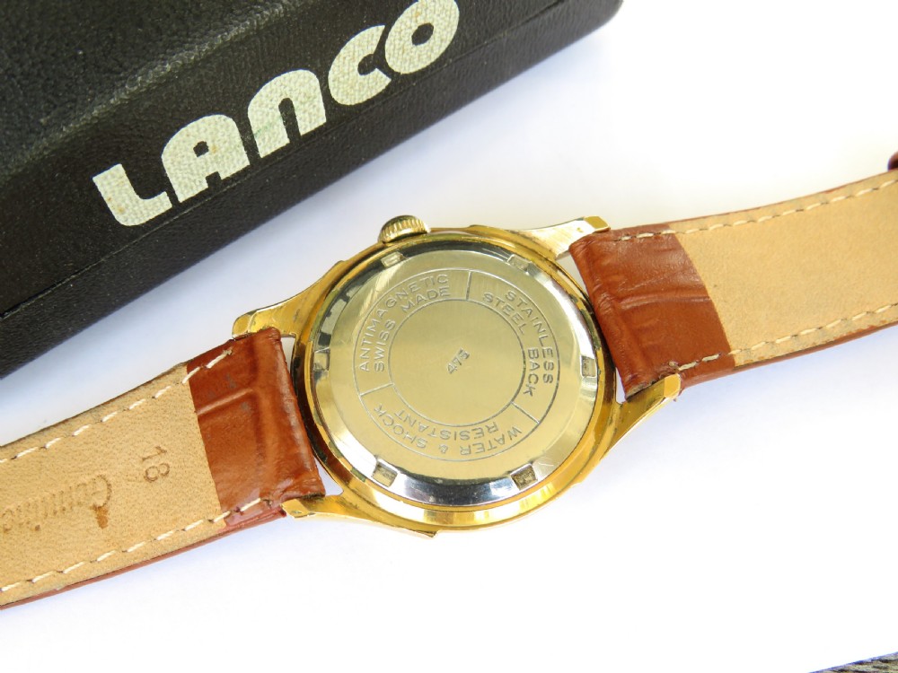 A 1950s gents Lanco Sport Swiss mechanical wristwatch featuring a gold-plated case, cream dial with arrow indices, and a textured brown leather strap. View IV