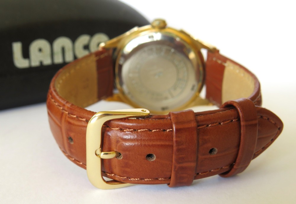 A 1950s gents Lanco Sport Swiss mechanical wristwatch featuring a gold-plated case, cream dial with arrow indices, and a textured brown leather strap. View V