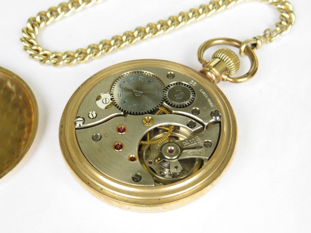 A gold-toned open-face pocket watch with a white dial, black Roman numerals, subsidiary seconds sub-dial, and an attached curb chain. View VI