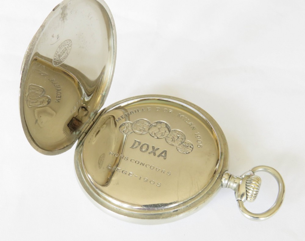 An open-face antique pocket watch featuring a white enamel dial with black Arabic numerals, a sub-seconds dial, and a polished silver-toned casing. View IV