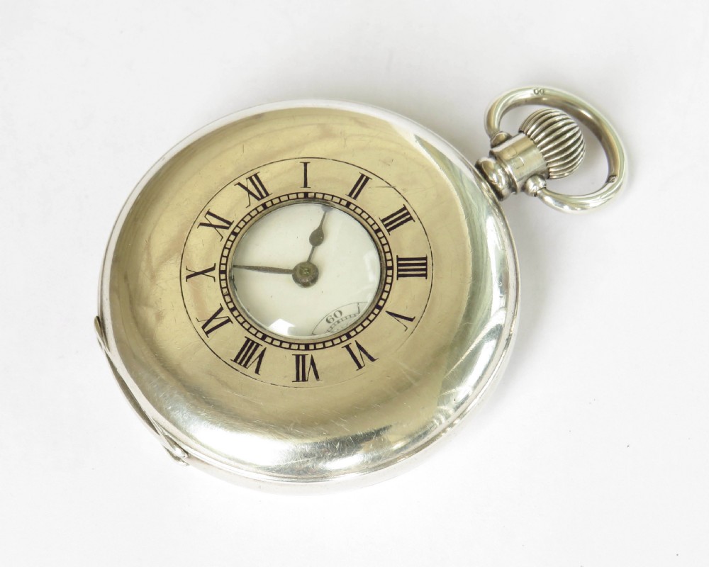 An open silver half hunter pocket watch featuring a white enamel dial with black Arabic numerals, a sub-seconds dial, and a polished silver casing. View II