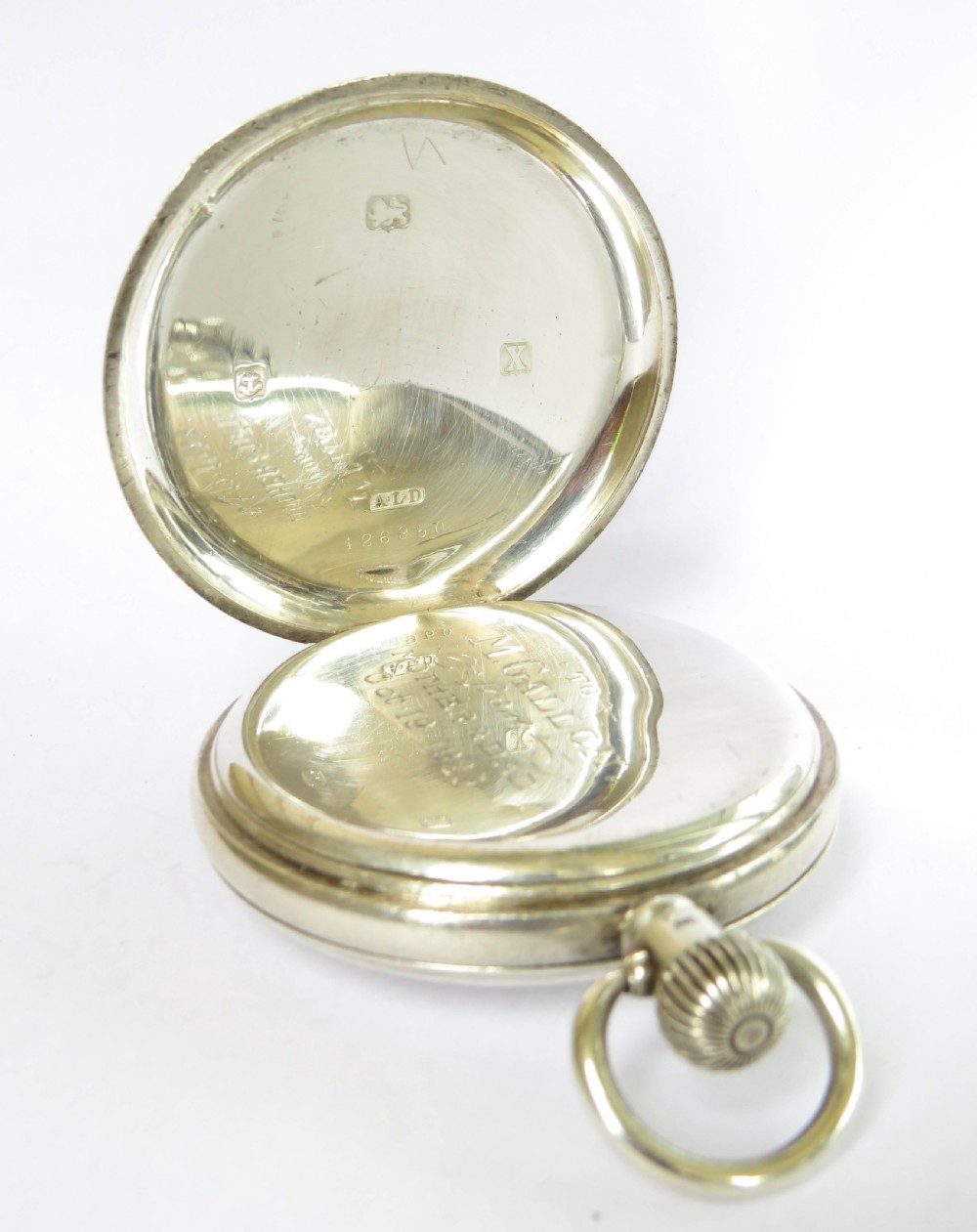 An open silver half hunter pocket watch featuring a white enamel dial with black Arabic numerals, a sub-seconds dial, and a polished silver casing. View III