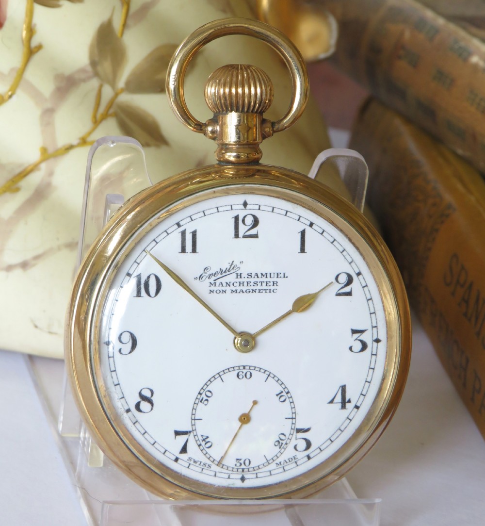 A 1930s gold-toned open-face pocket watch displaying a white dial with black Arabic numerals and a sub-seconds dial at six oclock. View II