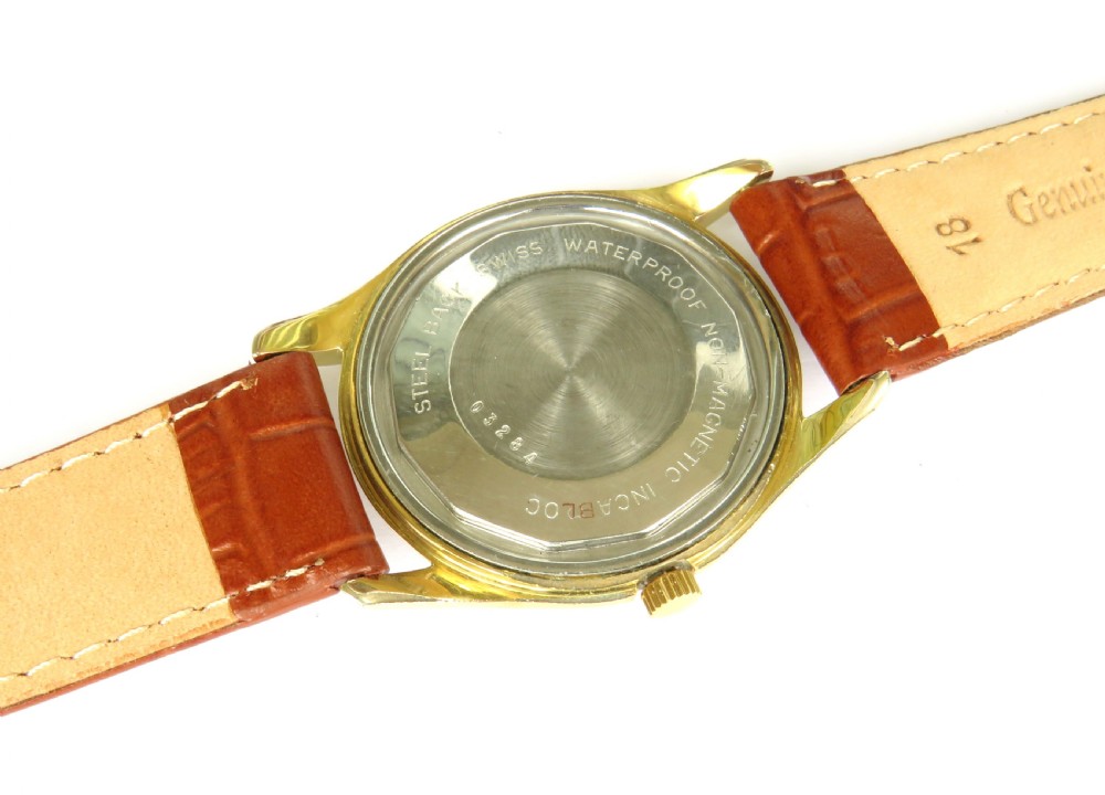 A 1950s gents Baume Bimatic wrist watch with a gold-plated round case, champagne dial, and textured brown leather strap. View III