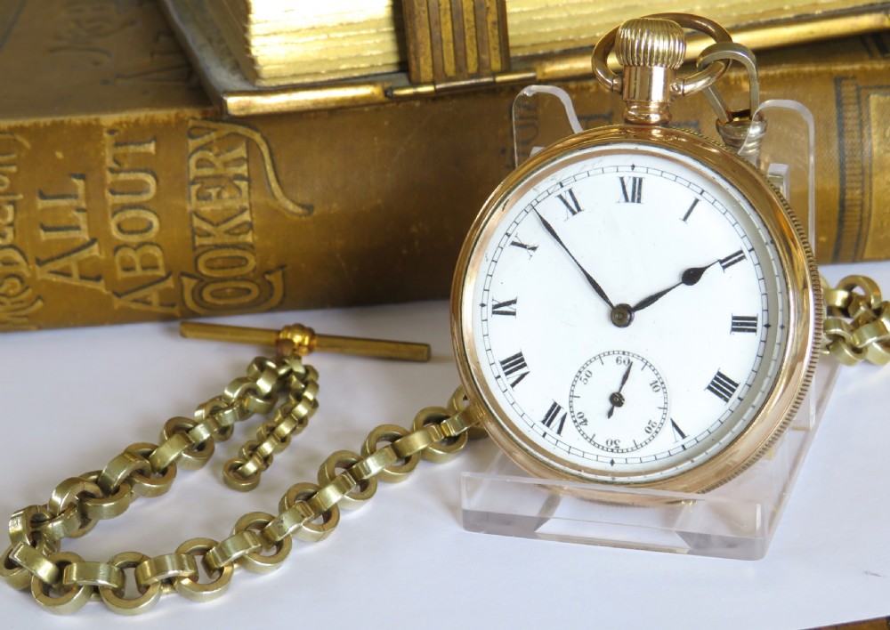 A 1930s gold-tone open-face pocket watch with a white dial, Roman numerals, a sub-seconds dial, and a linked Albert chain with a T-bar.