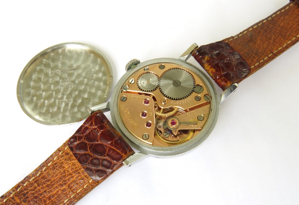 A 1944 vintage gentlemans Omega wristwatch featuring a round silver-tone case, cream dial with black Roman numerals, a sub-seconds dial at six oclock, and a textured brown leather strap. View III