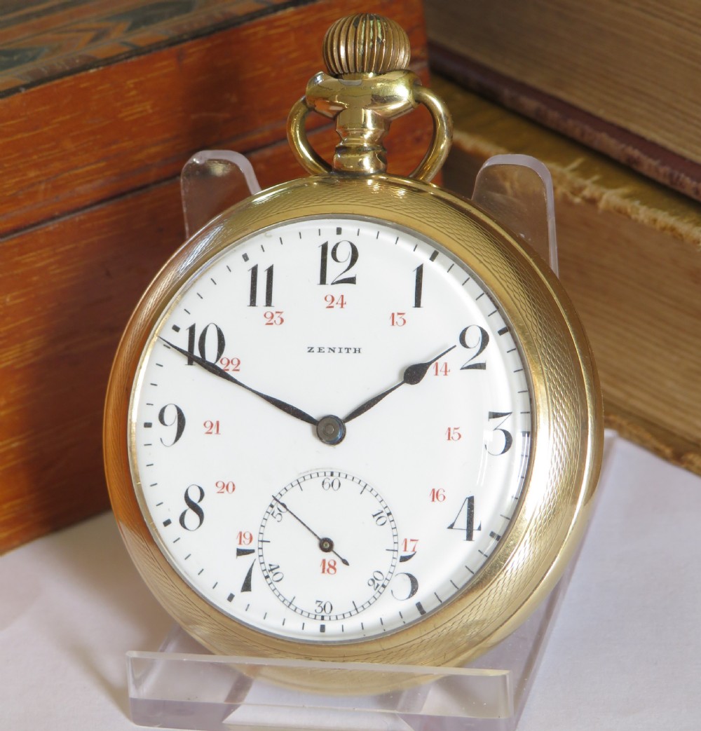 An open-face antique gold-tone pocket watch featuring a white enamel dial, black Arabic hour numerals, red 24-hour markings, and a subsidiary seconds sub-dial.