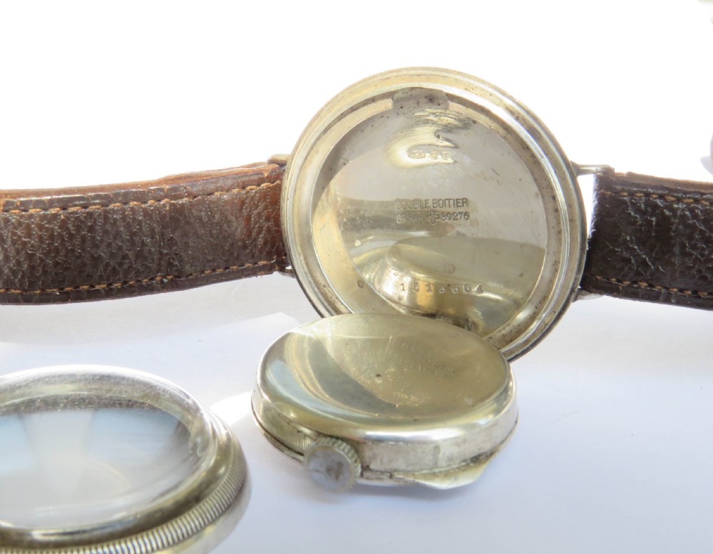 A 1930s gentlemans silver hermetic wrist watch with a circular coin-edge bezel, white enamel dial, sub-seconds display, and brown leather strap. View IV