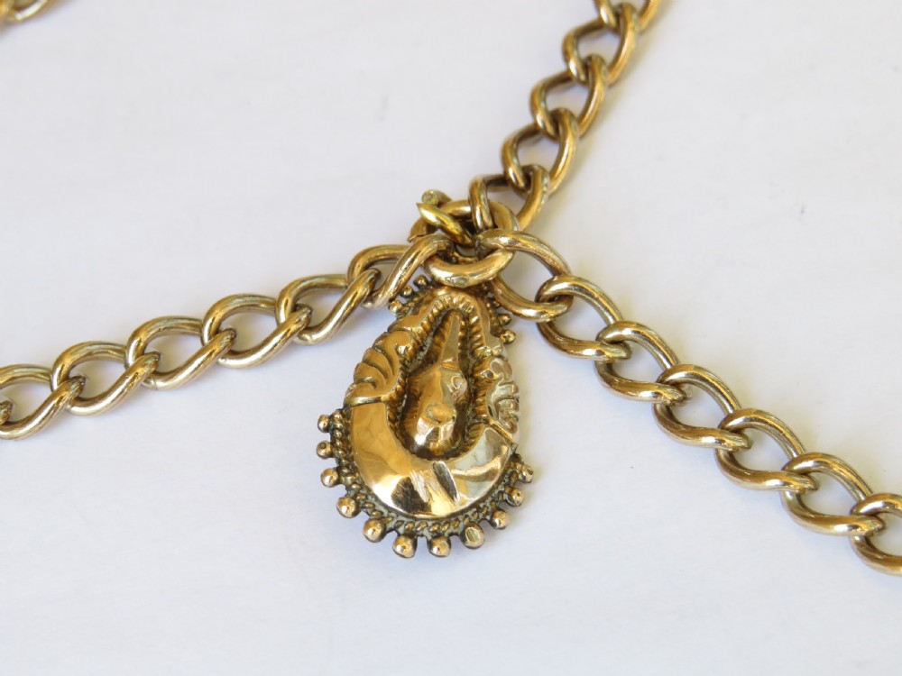 An antique rolled gold double Albert pocket watch chain featuring curb links, a central T-bar, two swivel clasps, and a decorative drop fob pendant. View II