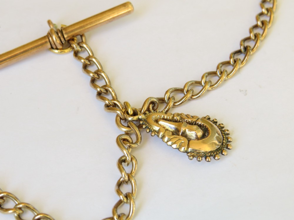 An antique rolled gold double Albert pocket watch chain featuring curb links, a central T-bar, two swivel clasps, and a decorative drop fob pendant. View III