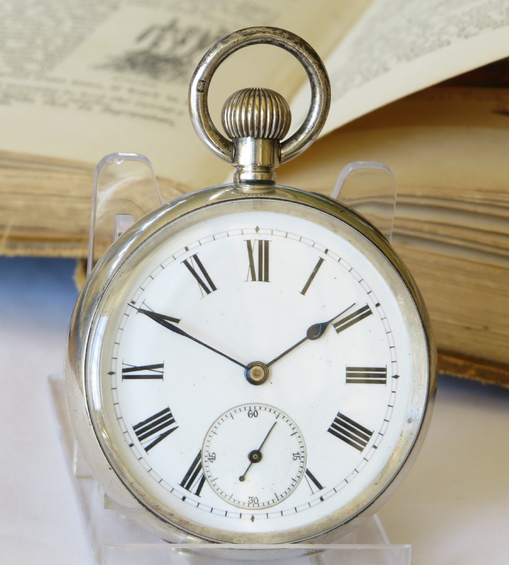 An antique open-face silver pocket watch featuring a white enamel dial with black Roman numerals and a subsidiary seconds dial at the base. View III