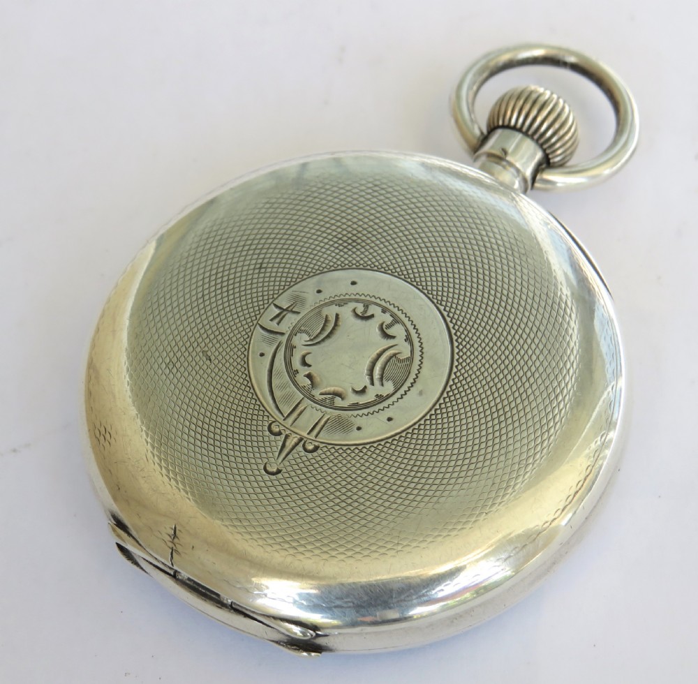 An antique open-face silver pocket watch featuring a white enamel dial with black Roman numerals and a subsidiary seconds dial at the base. View V