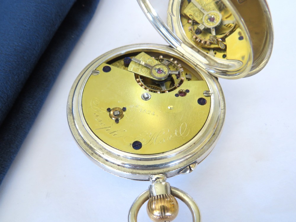 A late Victorian sterling silver half hunter pocket watch featuring dark blue enamel Roman numerals on the outer cover and a central glass window. View IV
