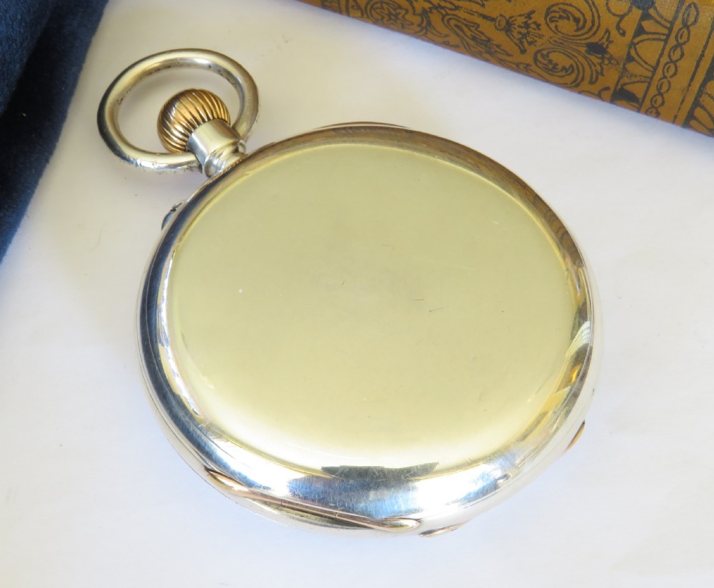 A late Victorian sterling silver half hunter pocket watch featuring dark blue enamel Roman numerals on the outer cover and a central glass window. View V