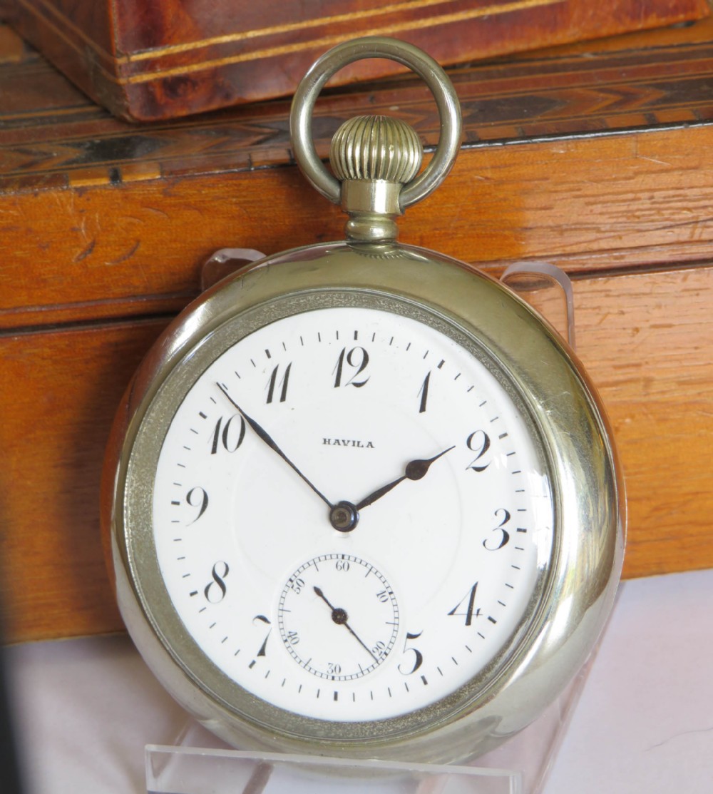 An antique open-face silver-toned pocket watch featuring a white enamel dial with black Arabic numerals and a subsidiary seconds dial.