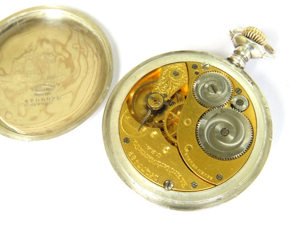An antique silver open-face Elgin pocket watch with a white enamel dial, Roman numerals, a subsidiary seconds dial, and an attached silver curb chain with a T-bar. View II