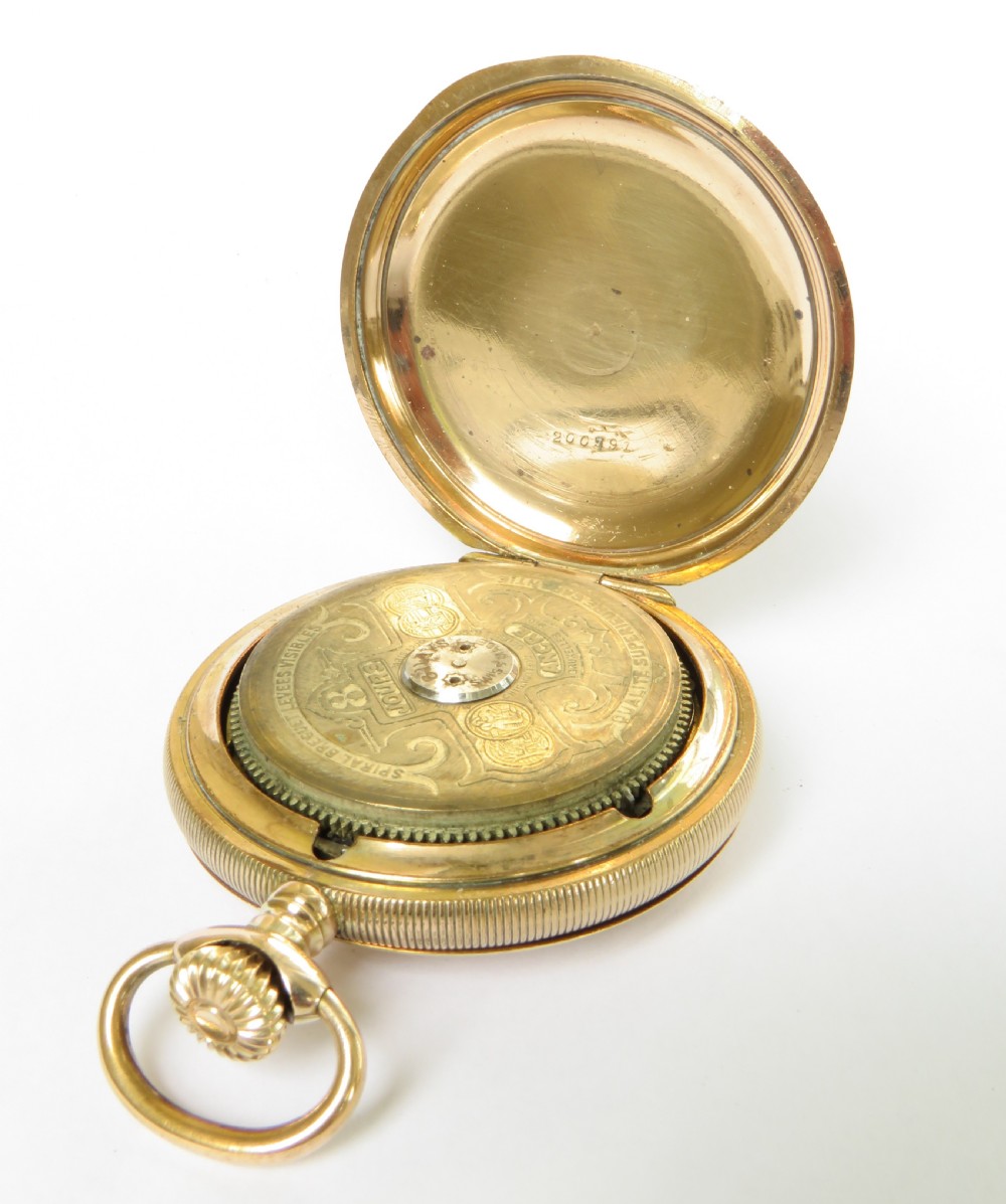 An open full hunter pocket watch featuring a gold case, a cream enamel dial with red Roman numeral cartouches, and an exposed balance bridge. View IV