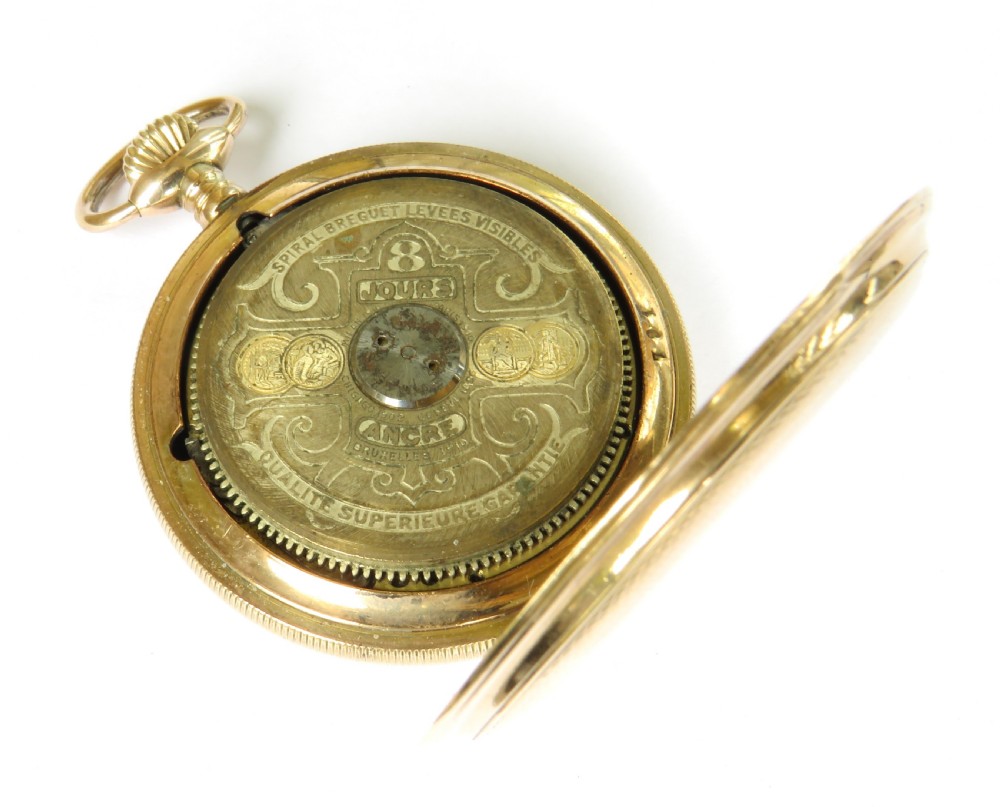 An open full hunter pocket watch featuring a gold case, a cream enamel dial with red Roman numeral cartouches, and an exposed balance bridge. View V