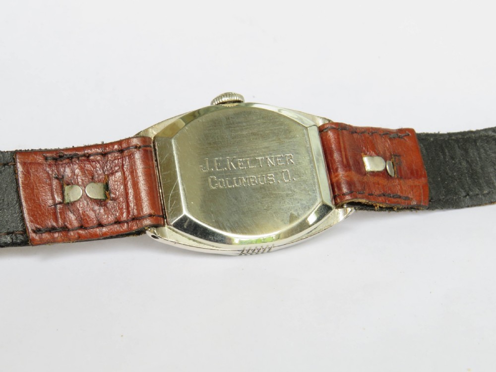 A 1930s Art Deco gents Hamilton wristwatch with a gold-toned tonneau case, cream dial, Arabic numerals, sub-seconds dial, and brown leather strap. View V