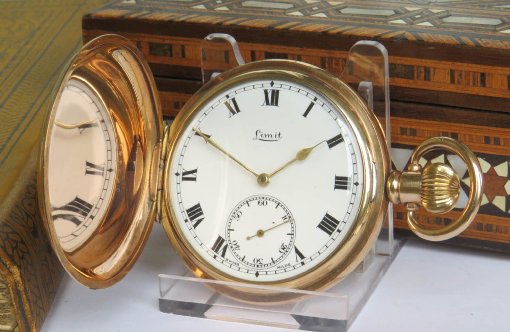 An open gold full hunter pocket watch displaying a white enamel dial with black Roman numerals and a subsidiary seconds dial.