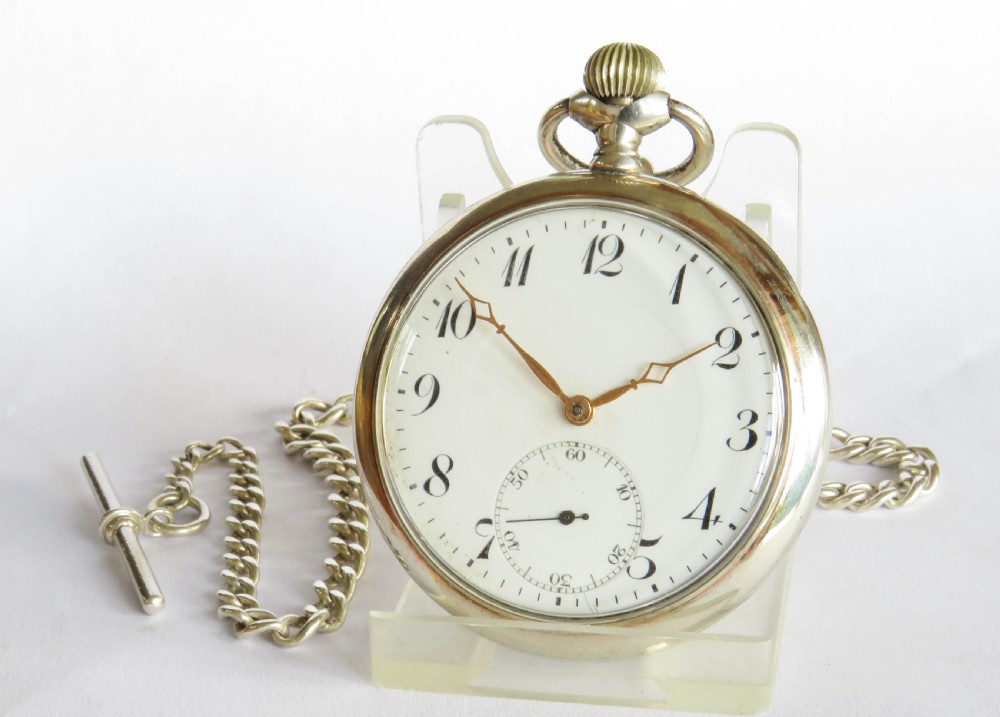 An Edwardian open-face silver pocket watch with a white enamel dial, Arabic numerals, a sub-seconds dial, and an attached silver T-bar chain.