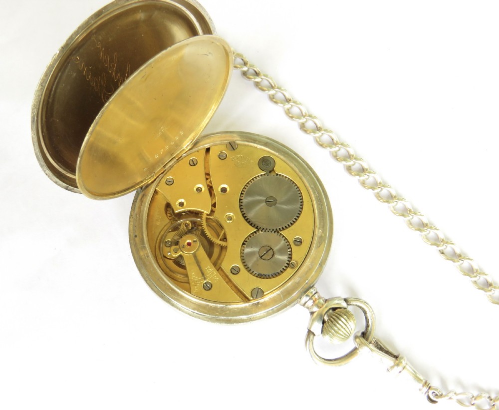 An Edwardian open-face silver pocket watch with a white enamel dial, Arabic numerals, a sub-seconds dial, and an attached silver T-bar chain. View IV
