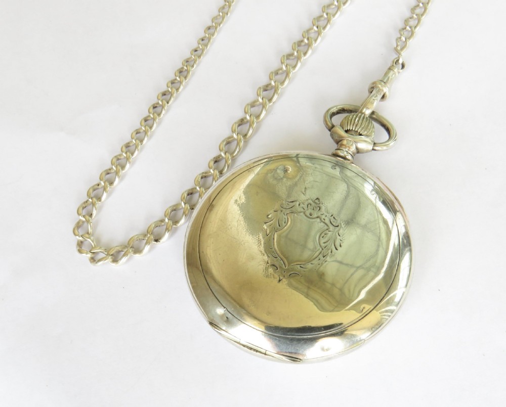 An Edwardian open-face silver pocket watch with a white enamel dial, Arabic numerals, a sub-seconds dial, and an attached silver T-bar chain. View V