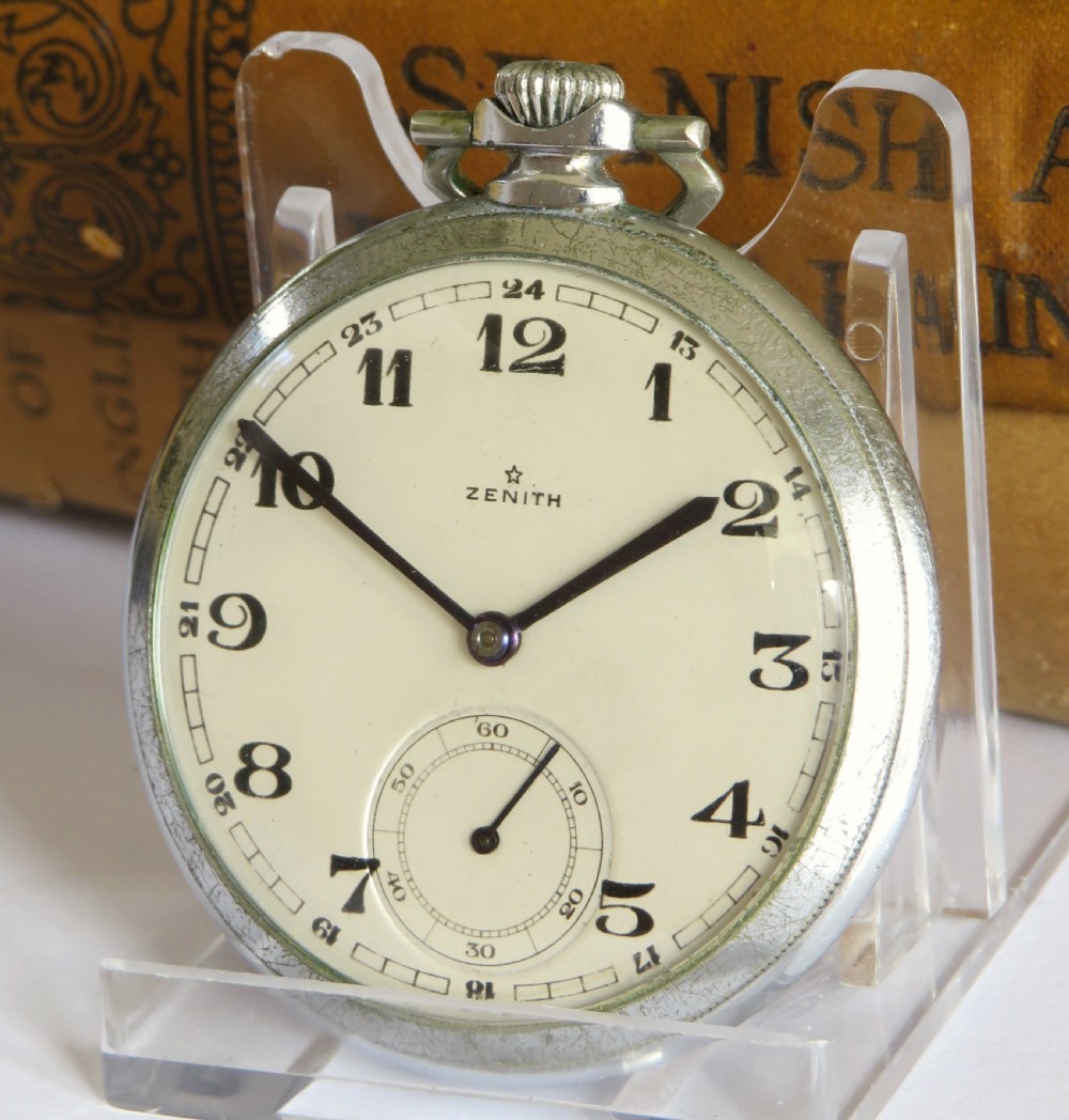 An open-face 1930s Zenith pocket watch featuring a cream dial, black Arabic numerals, a sub-seconds dial, and a silver-tone metal case.