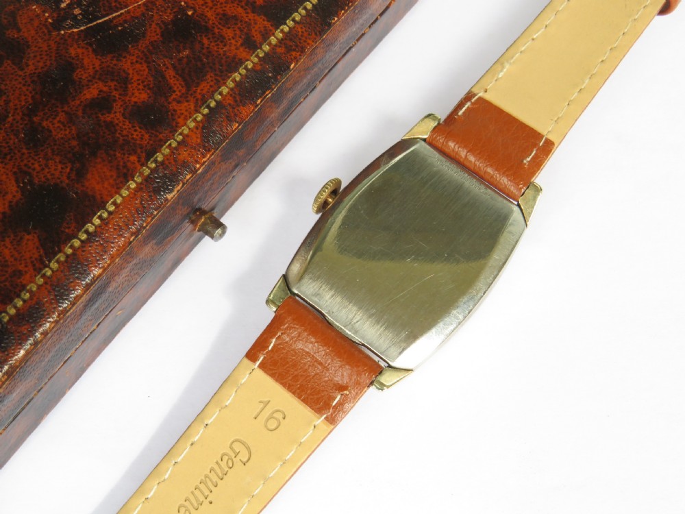 A 1948 Elgin mens wristwatch featuring a rectangular gold-toned case, cream dial with gold Arabic numerals, sub-seconds dial, and tan leather strap. View V