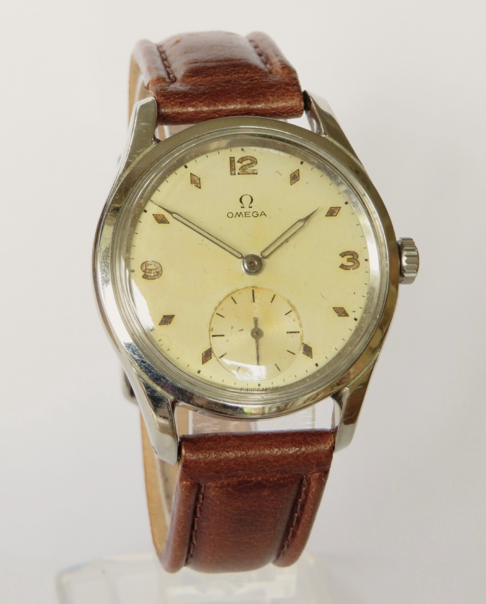A 1950s gents Omega wristwatch featuring a cream dial with a sub-seconds subdial, fitted with a brown leather strap alongside a brown leather presentation box. View II