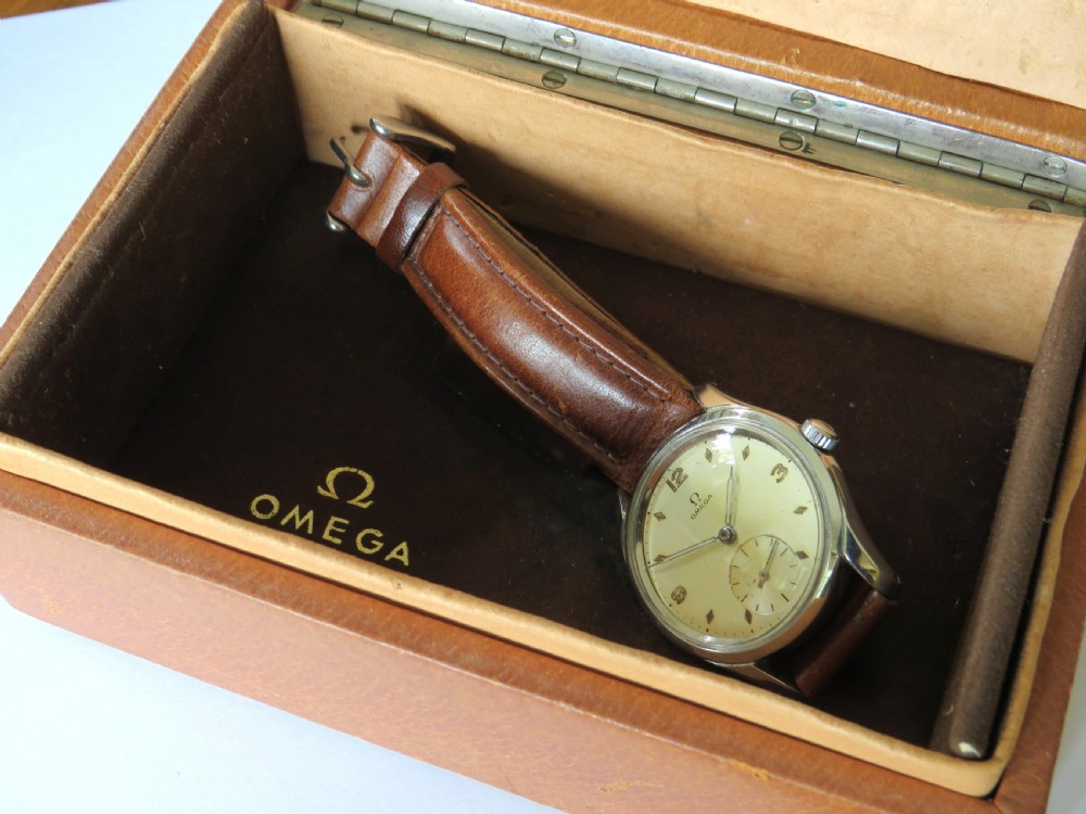 A 1950s gents Omega wristwatch featuring a cream dial with a sub-seconds subdial, fitted with a brown leather strap alongside a brown leather presentation box. View III