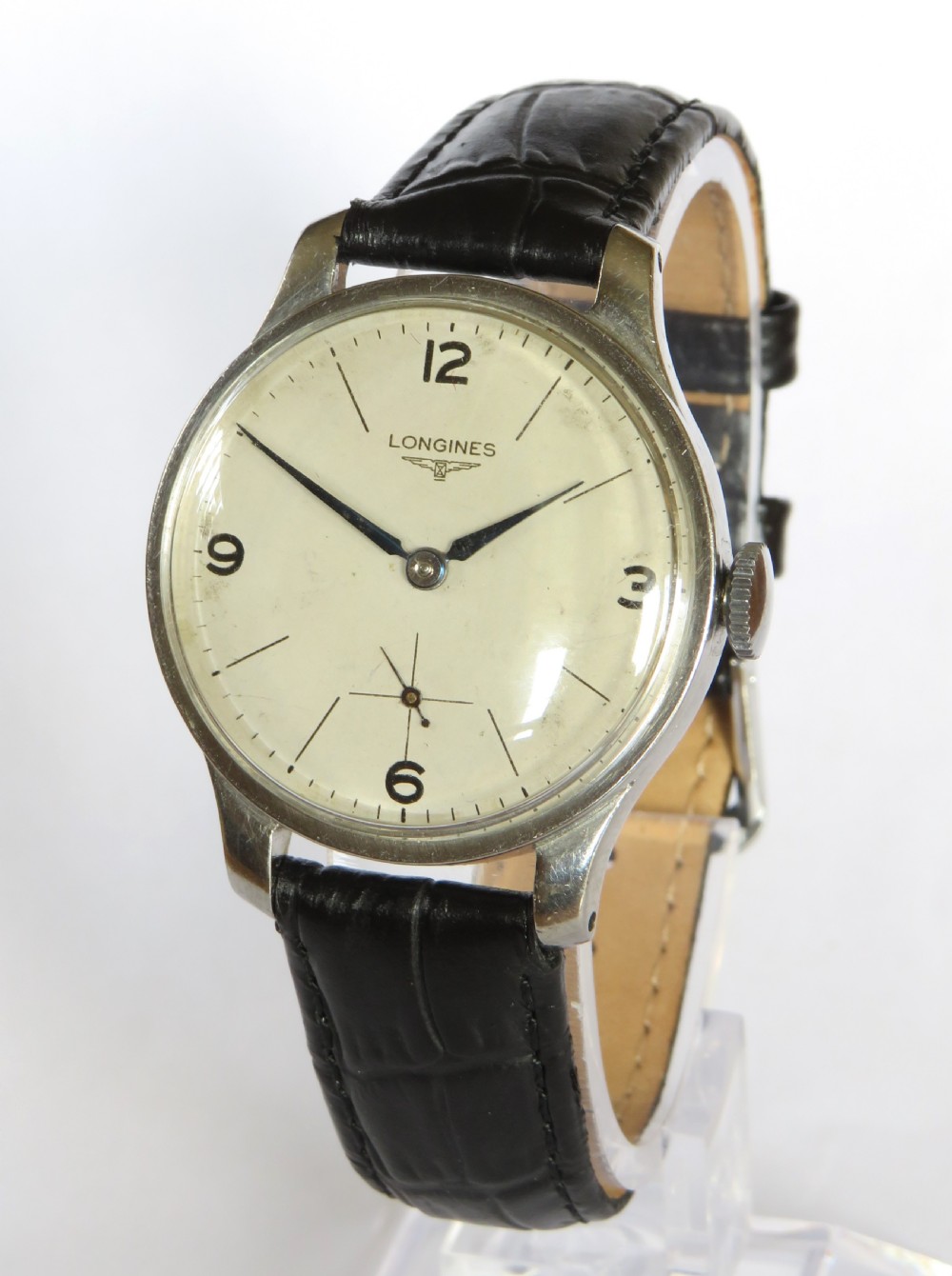 A vintage 1940s gents Longines wristwatch featuring a round silver-tone case, cream dial with sub-seconds register, and a black leather strap.