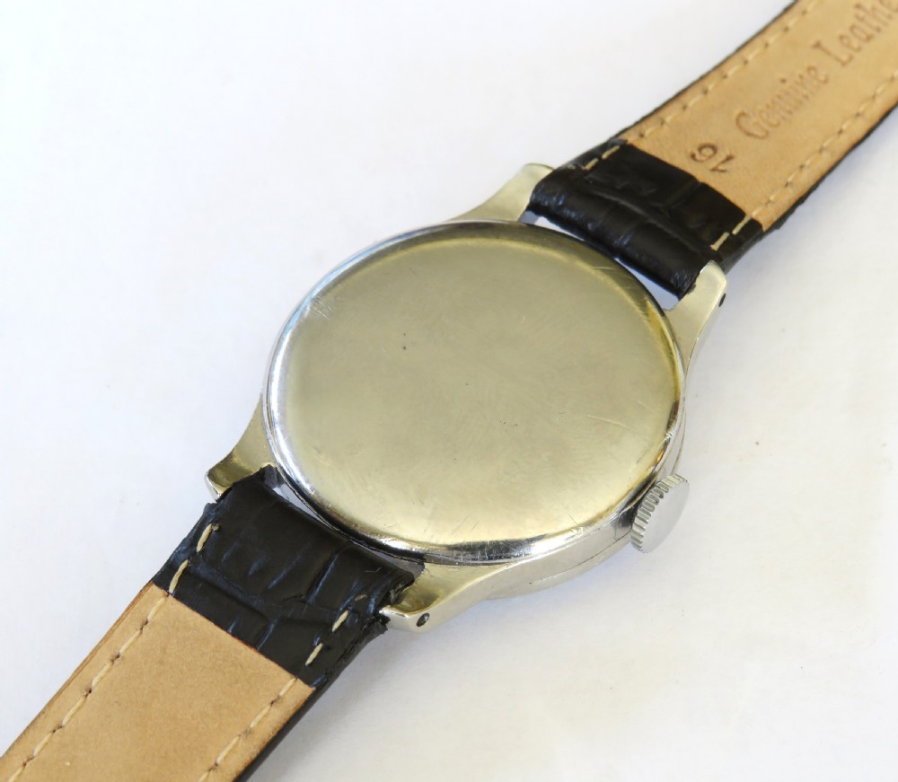 A vintage 1940s gents Longines wristwatch featuring a round silver-tone case, cream dial with sub-seconds register, and a black leather strap. View VI