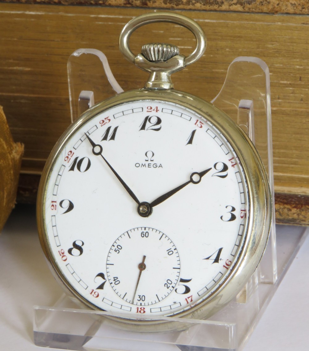 A 1943 open-face Omega pocket watch featuring a white enamel dial, black Arabic numerals, a sub-seconds dial, and a silver-toned metal case.