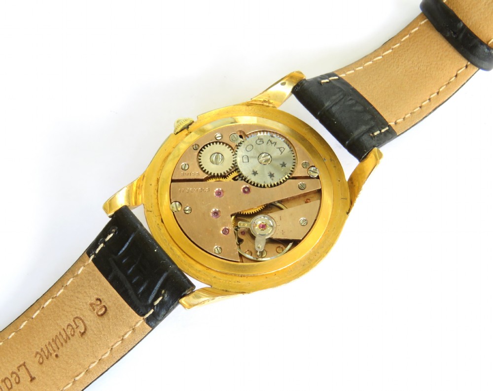 A 1950s gents Dogma Prima wristwatch featuring a gold-toned case, champagne dial with sub-seconds subdial, and black leather strap. View III