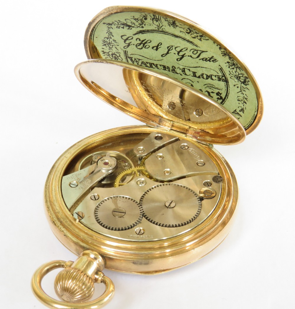 A 1930s open-face pocket watch featuring a gold-toned casing, white enamel dial with black Roman numerals, and a subsidiary seconds sub-dial at six oclock. View IV