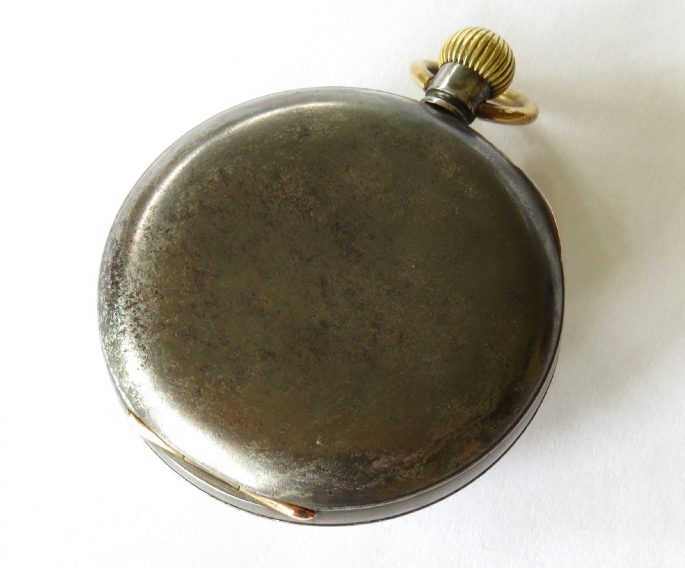 An antique open-face gunmetal pocket watch with a white enamel Roman numeral dial and brass Albert chain, set inside a red presentation case. View VII