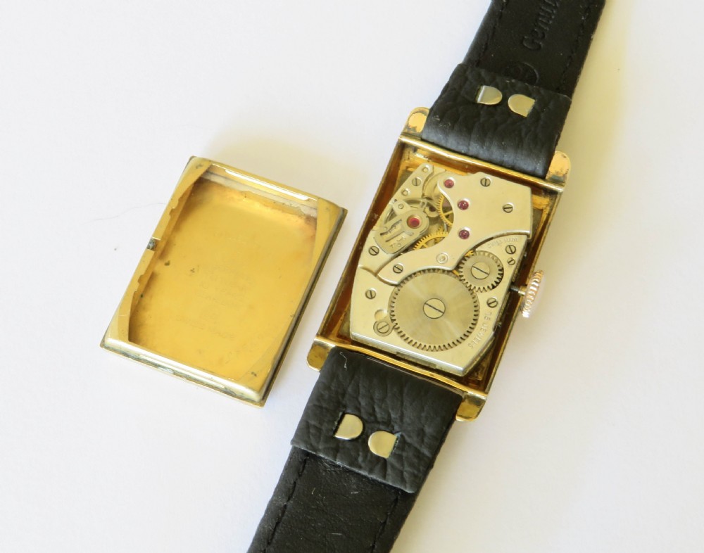 A 1930s rectangular Art Deco wristwatch by Rotary with a gold-plated case, cream dial with Arabic numerals, sub-seconds subdial, and a black leather strap. View III
