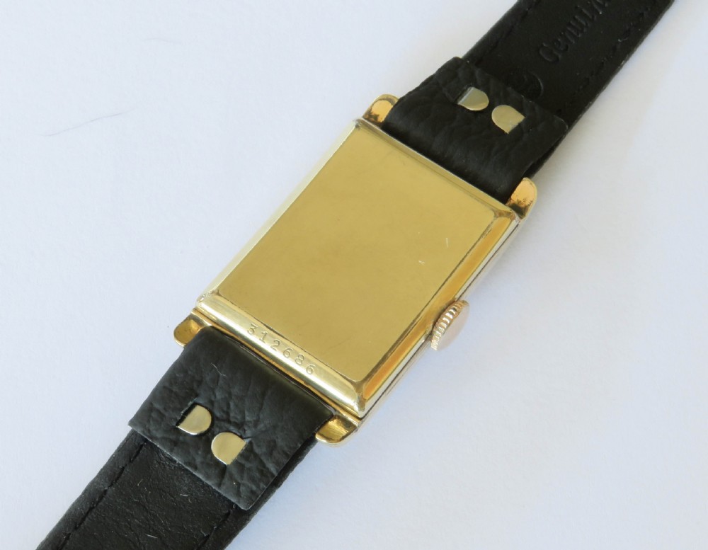 A 1930s rectangular Art Deco wristwatch by Rotary with a gold-plated case, cream dial with Arabic numerals, sub-seconds subdial, and a black leather strap. View IV