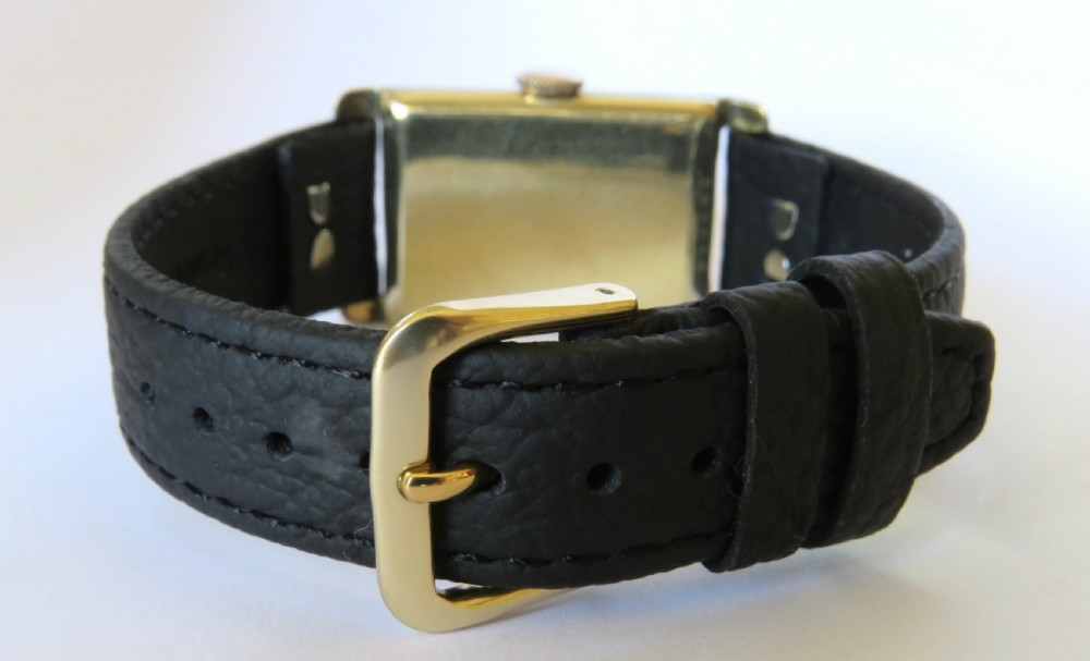 A 1930s rectangular Art Deco wristwatch by Rotary with a gold-plated case, cream dial with Arabic numerals, sub-seconds subdial, and a black leather strap. View V