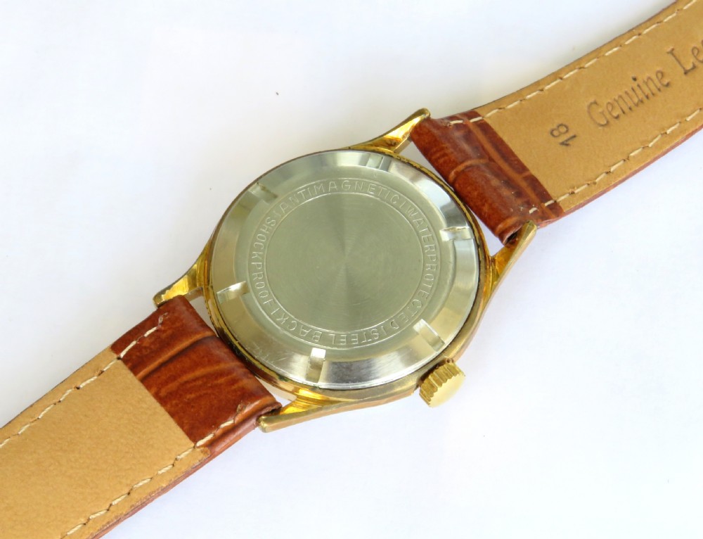 A 1960s gents Gloriosa mechanical wrist watch featuring a gold-toned case, cream dial with gold hour markers, and a textured brown leather strap. View IV